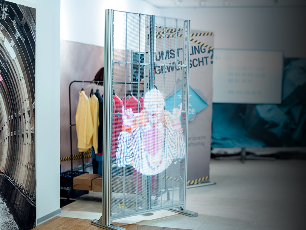 Freistehende transparente LED-Wand mit Standfüßen und animiertem Content.