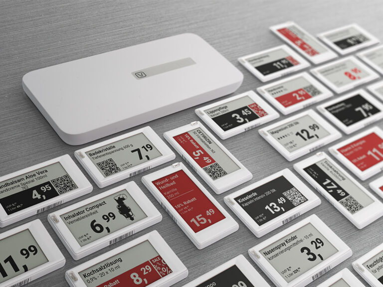 Elektronische Preisschilder (ESL) mit QR-Codes und einer Funk-Basisstation auf dem Tisch.